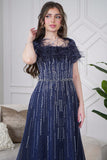 Long evening dress decorated with rhinestones and feathers in navy blue 