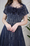 Long evening dress decorated with rhinestones and feathers in navy blue 