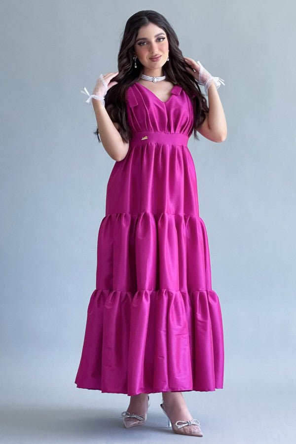 Long dress with layers and a bow on the shoulder, fuchsia color