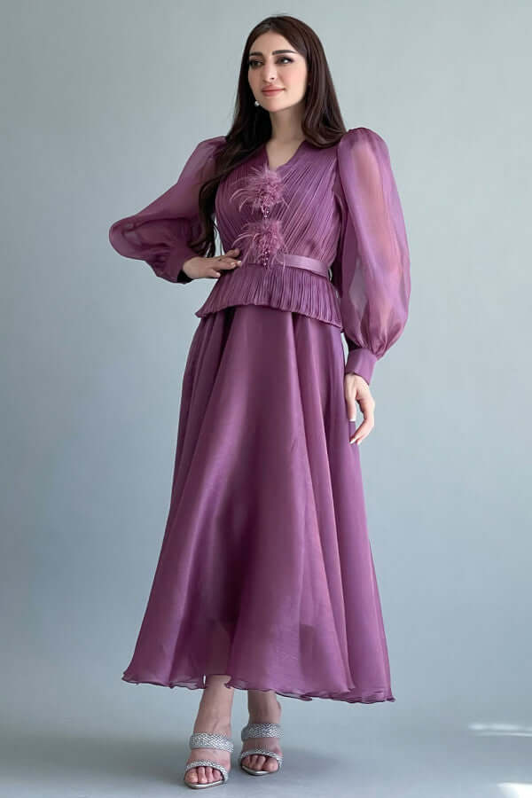 A mauve color dress decorated with feathers and a lulu on the chest